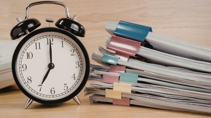 Unpaid overtime hours represented by an alarm clock next to stacked work documents