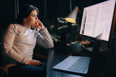 Employee working off the clock at night showing common overtime violations by employers