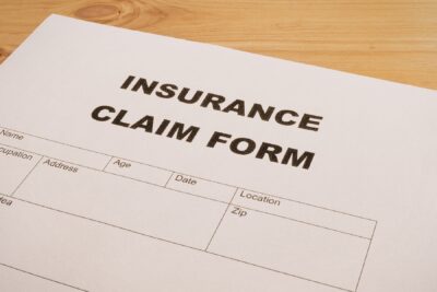 Insurance claim form on a wooden desk, representing the step of notifying the insurance company during the car accident settlement process.