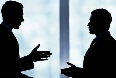 Franchisees and a franchisor reviewing agreement terms during a franchise dispute